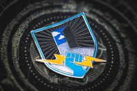 Everyone Can Play collectable pin is a shield with an open door to the sky in the background and a light blue fist holding a yellow lightning bolt in the foreground