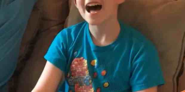 Thad, a young man wearing a blue shirt holding a controller in his hands.