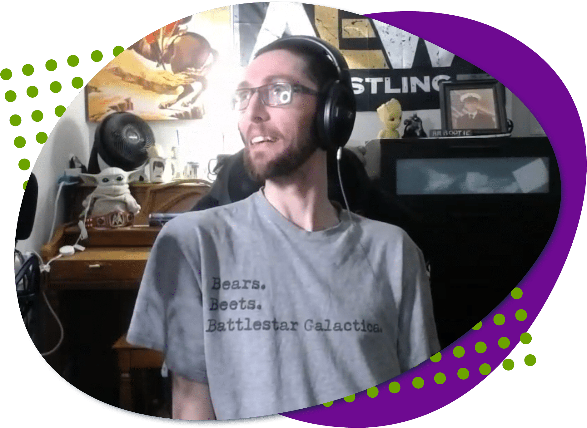 A photo of Anthony, he is wearing glasses, a headset and a gray t-shirt that says bears, beets, battlestar galactica