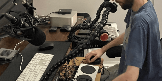 A photo of Anthony sitting at a desk with his gaming setup in front of him
