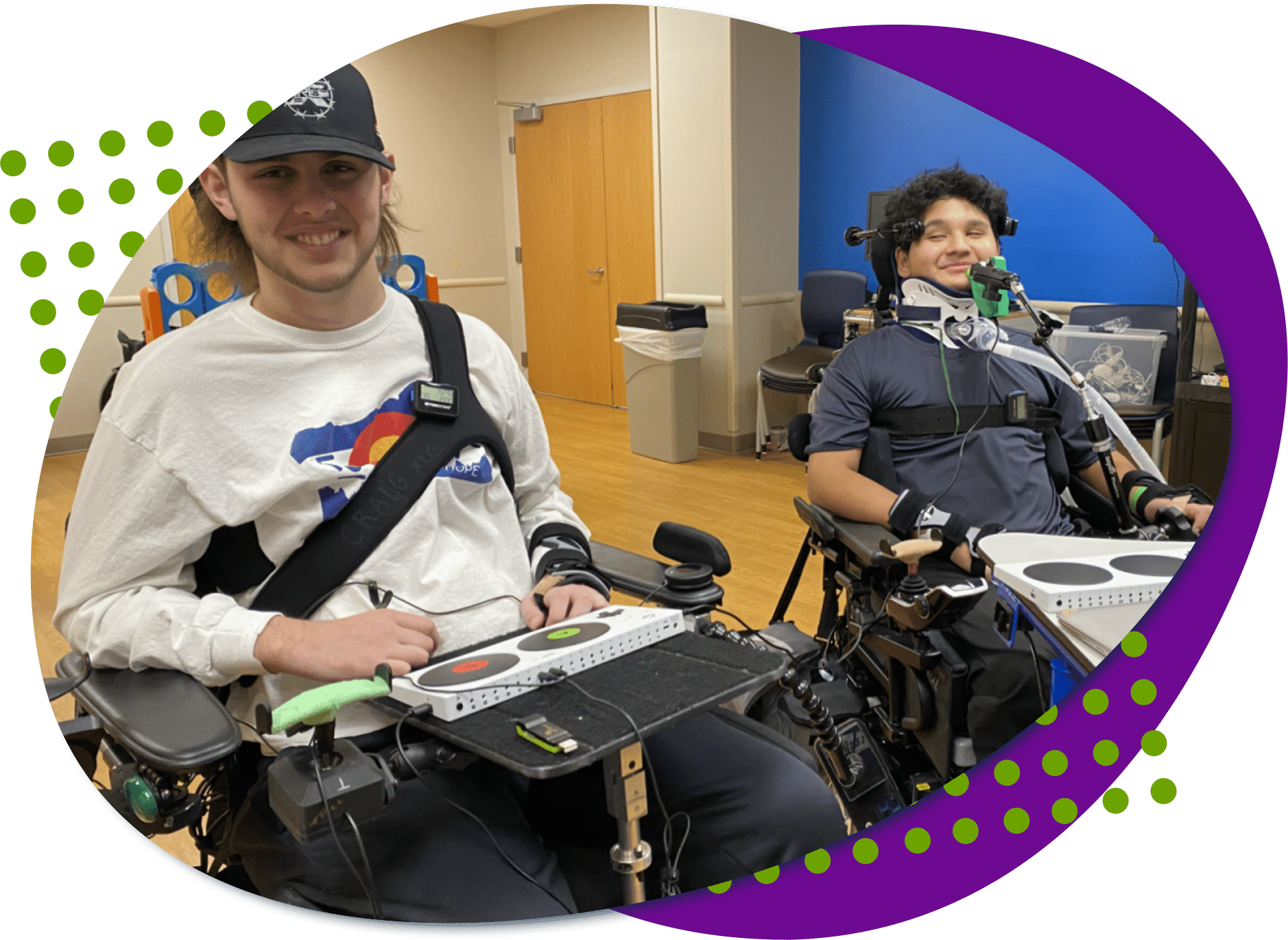 Two teen boys, are both using wheelchairs. They are getting set up with adaptive gaming controllers to play video games together