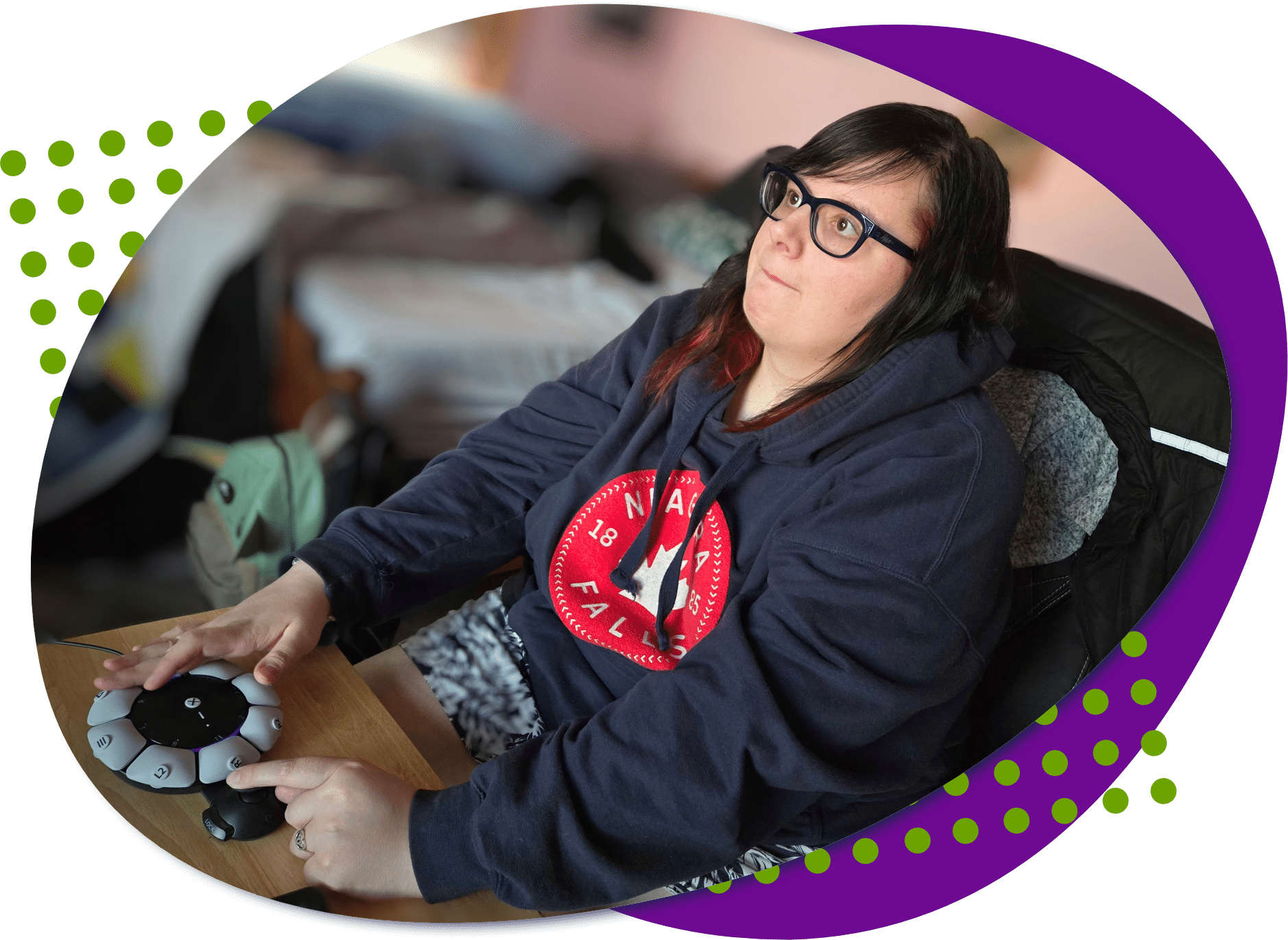 A photo of Courtney. She has long dark hair and she is wearing glasses. She is using the Sony Access controller to play a video game.