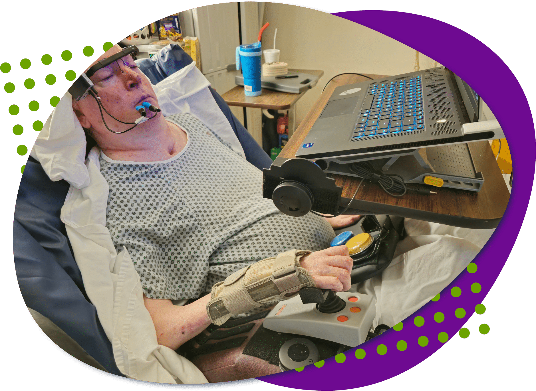 A photo of David using a joystick and buttons to play a video game on his laptop