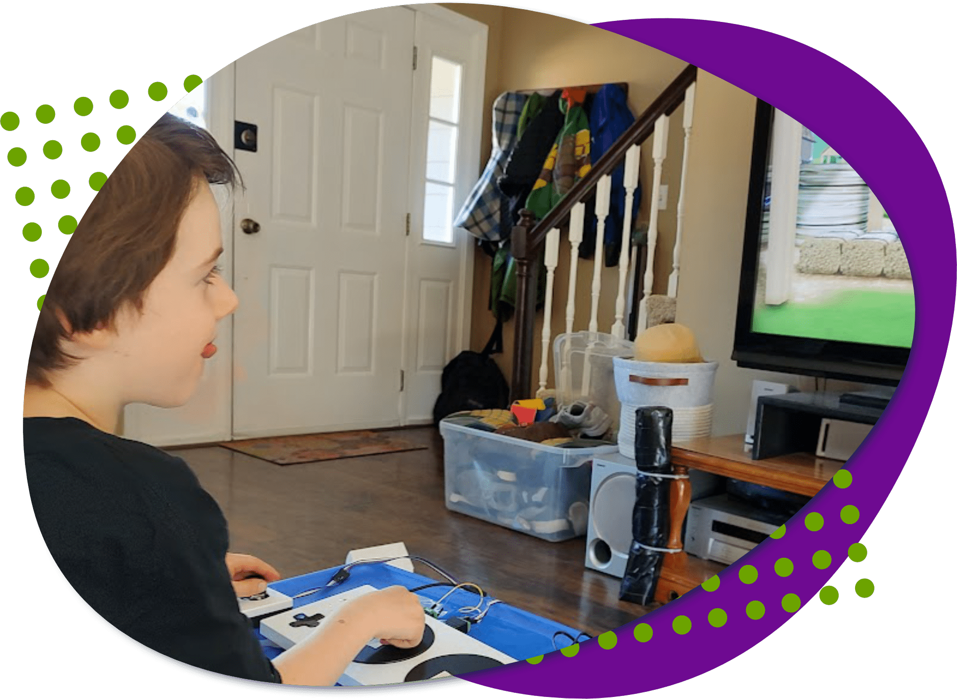 A photo of Elliott playing a video game with his adaptive gaming controller setup