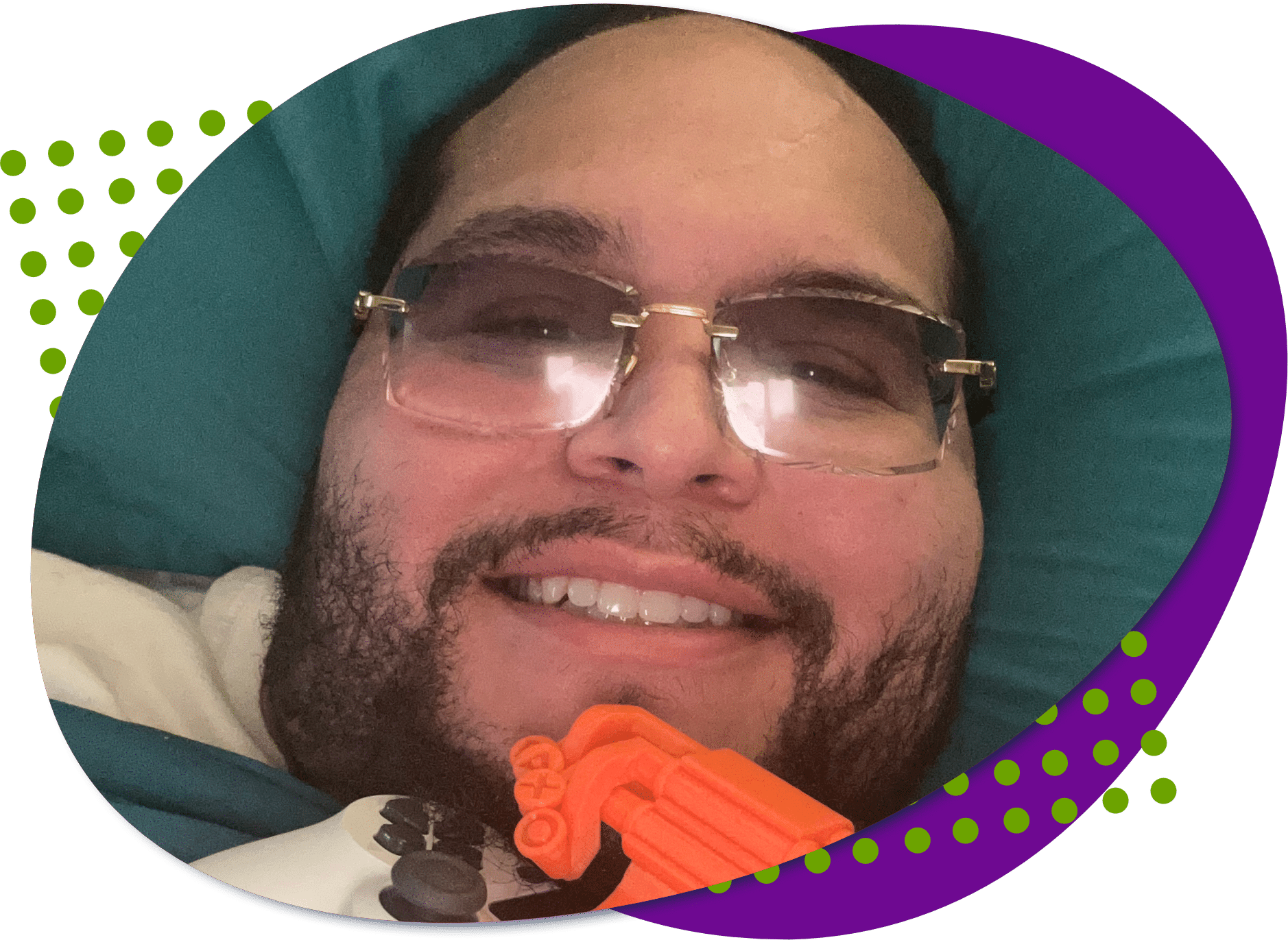 A photo of Elvin who has dark hair, a beard and is wearing glasses, and his Controller with a 3D-printed one-handed snap-on device