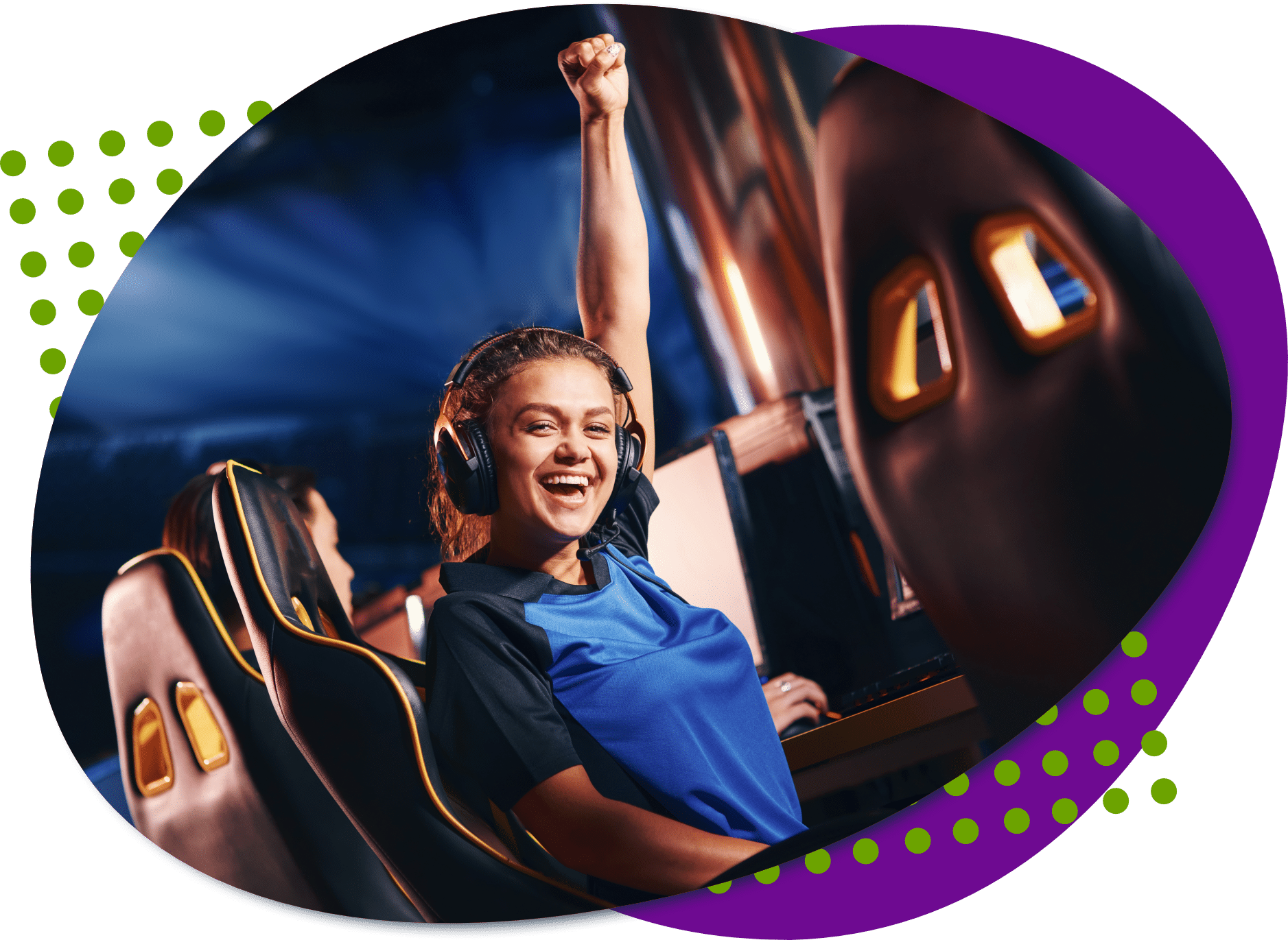 A young woman sitting in a gaming chair wearing headphones cheering with her hand in the air