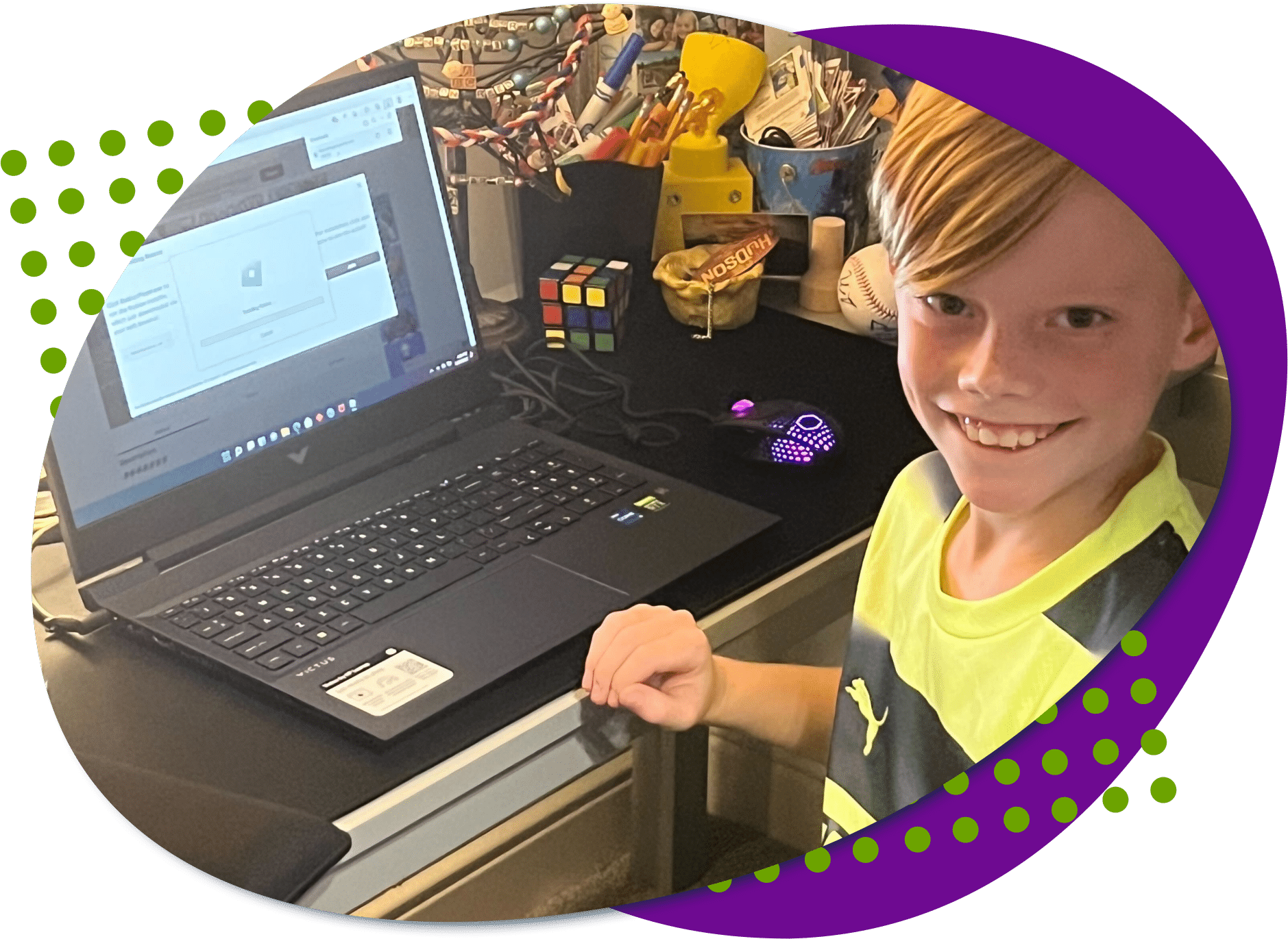 Husdon, a young man born with a limb difference looking at the camera with his new gaming laptop he just got.