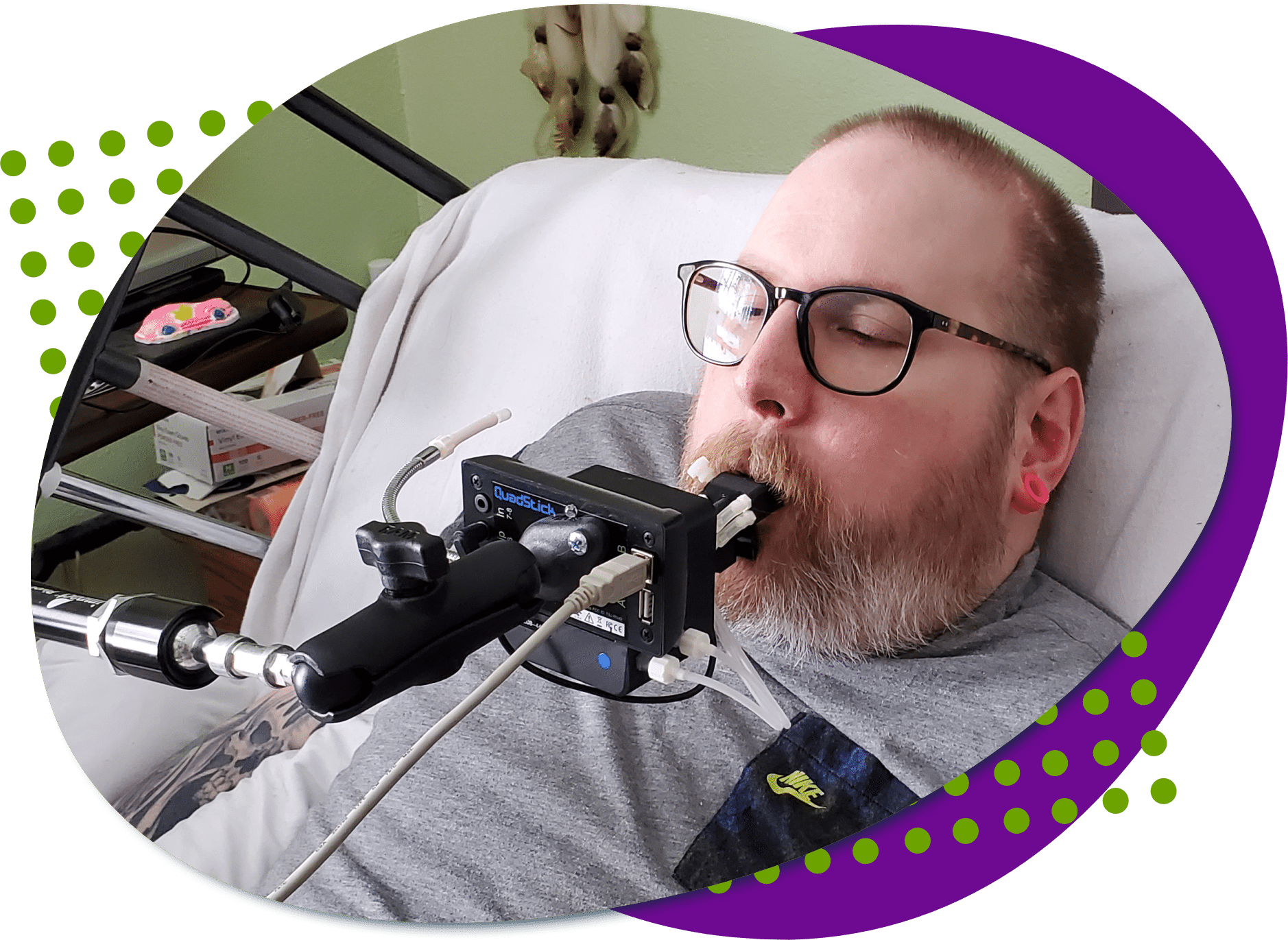 An individual with a beard and black glasses playing video games using a QuadStick